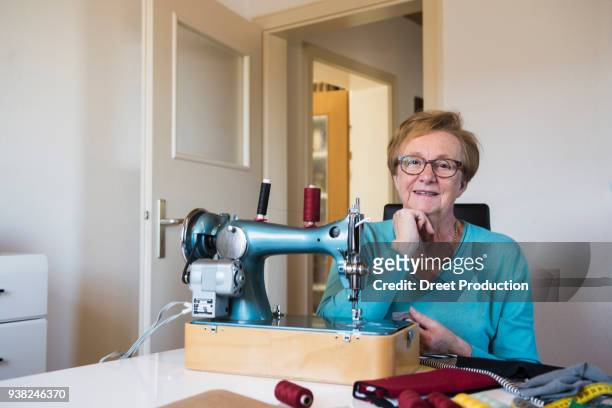 old woman working at sewing machine - das leben zu hause stock pictures, royalty-free photos & images