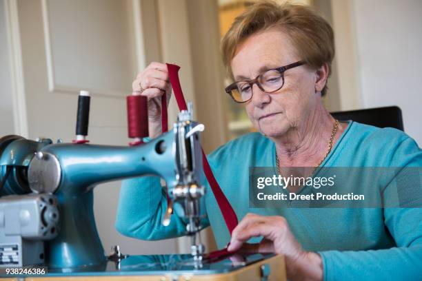 old woman sewing on a machine - eine frau allein fotografías e imágenes de stock