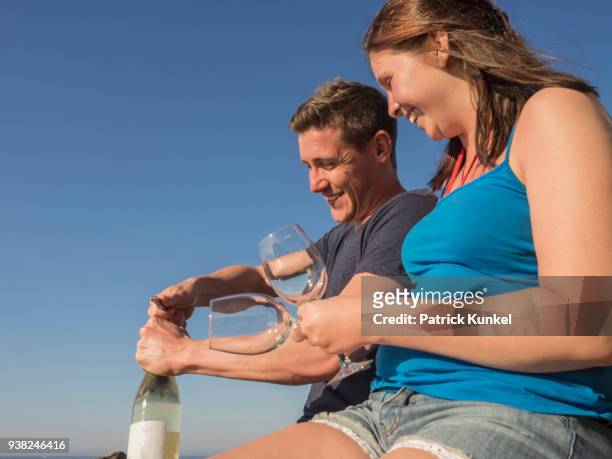 young couple drinking white wine, beach of azkorri, getxo, biscay, spain - sorglos stockfoto's en -beelden