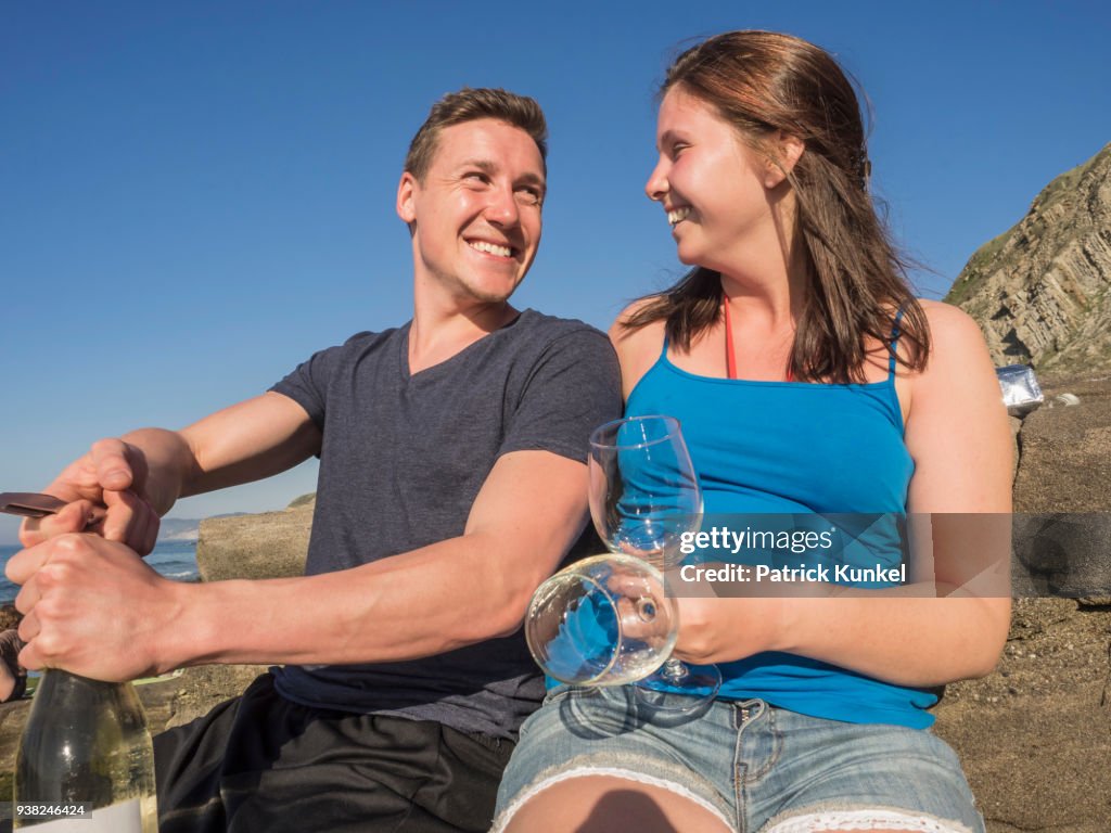 Young couple drinking white wine, Beach of Azkorri, Getxo, Biscay, Spain