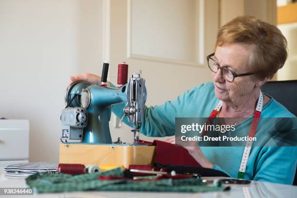 old woman sewing on a machine - altötting stock-fotos und bilder