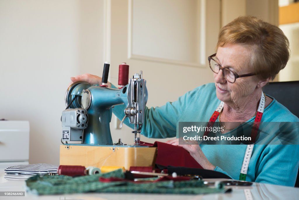 Old woman sewing on a machine