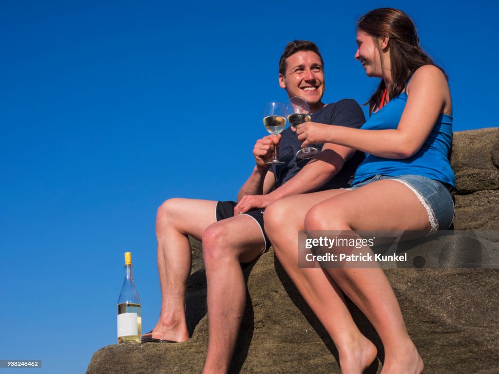 Young couple drinking white wine, Beach of Azkorri, Getxo, Biscay, Spain