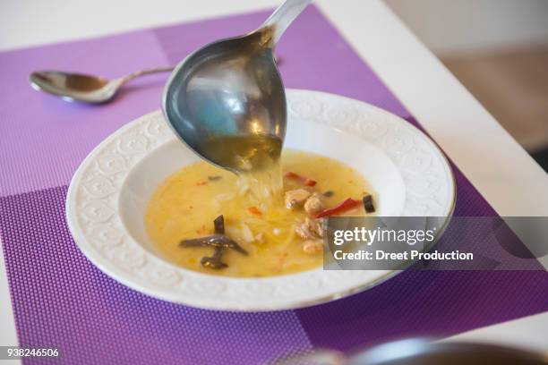 noodle soup being poured in a soup plate on dining table - essen tisch ストックフォトと画像