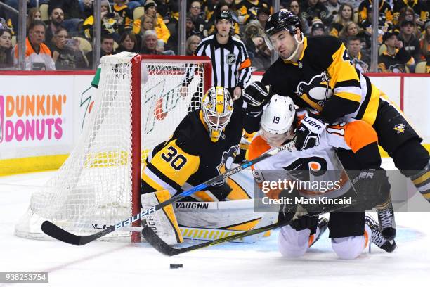 Justin Schultz of the Pittsburgh Penguins checks Nolan Patrick of the Philadelphia Flyers to the ice at PPG PAINTS Arena on March 25, 2018 in...