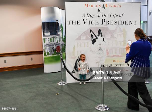 Joy Amini takes a photo of her two-year-old dither Emma Grace Amini in front of a lager copy of Second Daughter Charlotte Pence and Second Lady Karen...