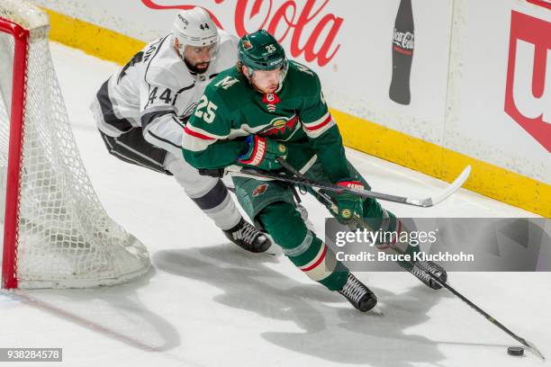 Jonas Brodin of the Minnesota Wild skates with the puck while Nate Thompson of the Los Angeles Kings defends during the game at the Xcel Energy...