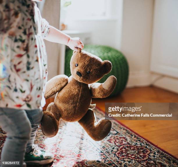 child holding brown teddy - child teddy bear stock pictures, royalty-free photos & images