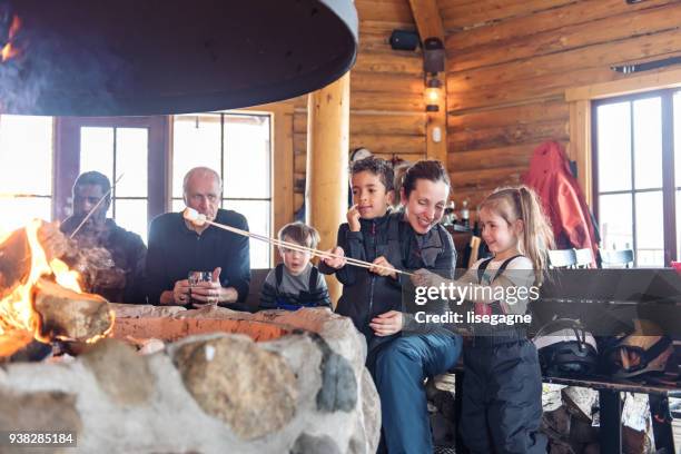 families in a ski resort, apres-ski relaxing - winter cabin stock pictures, royalty-free photos & images