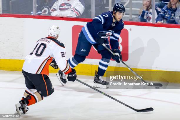 Ben Chiarot of the Winnipeg Jets plays the puck along the boards as Jason Chimera of the Anaheim Ducks defends during second period action at the...