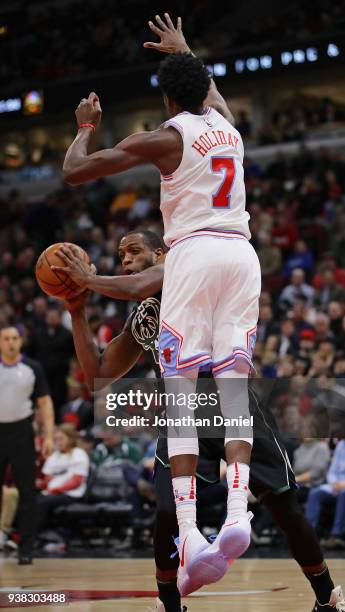 Khris Middleton of the Milwaukee Bucks tries to move against Justin Holiday of the Chicago Bulls at the United Center on March 23, 2018 in Chicago,...