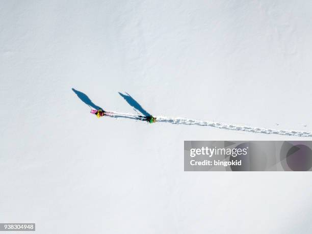 twee wandelaars met lange schaduwen lopen over sneeuw (luchtfoto) - long distance relationship stockfoto's en -beelden