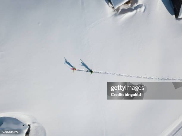 two hikers with raised arms in deep snow from above - ski hut stock pictures, royalty-free photos & images