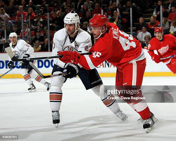 Jakub Kindl of the Detroit Red Wings clears the puck from Dustin Penner of the Edmonton Oilers during an NHL game at Joe Louis Arena on December 3,...