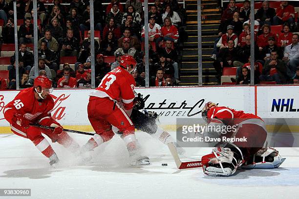 Jakub Kindl of the Detroit Red Wings skates towards the net as teammate, goalie Jimmy Howard gets into position and Pavel Datsyuk ties up Andrew...