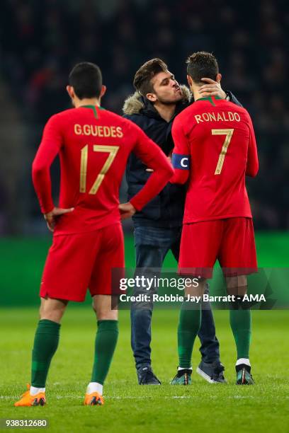 Fan of Portugal and Cristiano Ronaldo of Portugal runs on to the field to give Cristiano Ronaldo of Portugal a kiss during the International Friendly...