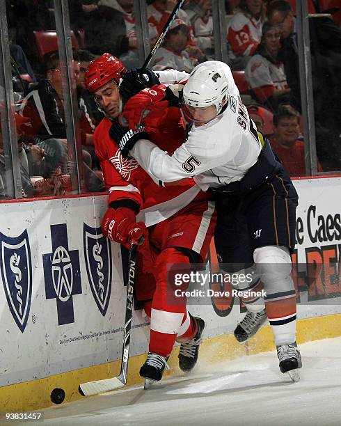 Todd Bertuzzi of Detroit Red Wings is checked into the sideboards by Ladislav Smid of the Edmonton Oilers during an NHL game at Joe Louis Arena on...