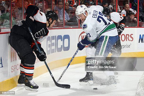 Alexander Edler of the Vancouver Canucks defends against Dan Carcillo of the Philadelphia Flyers on December 3, 2009 at Wachovia Center in...