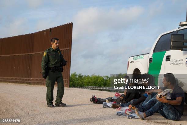 Border Patrol agent apprehends illegal immigrants shortly after they crossed the border from Mexico into the United States on Monday, March 26, 2018...