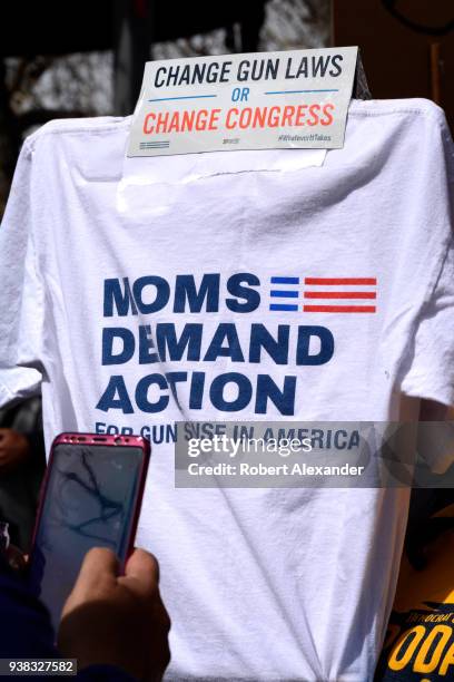 Gun control advocate holds a sign made from a 'Moms Demand Action' T-shirt at a 'March For Our Lives' rally in Santa Fe, New Mexico. The rally and...