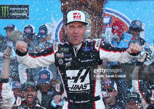 Clint Bowyer, driver of the Haas Automation Demo Day Ford, celebrates in Victory Lane after winning the weather delayed Monster Energy NASCAR Cup...
