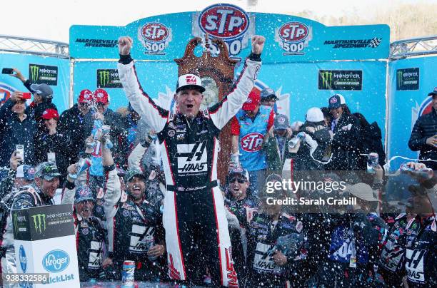 Clint Bowyer, driver of the Haas Automation Demo Day Ford, celebrates in Victory Lane after winning the weather delayed Monster Energy NASCAR Cup...