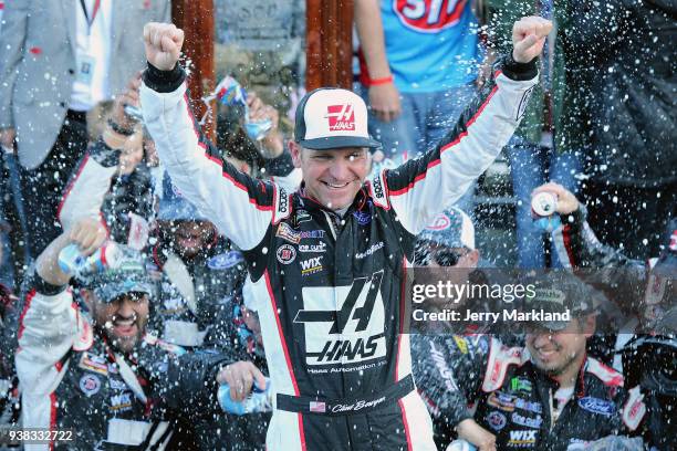 Clint Bowyer, driver of the Haas Automation Demo Day Ford, celebrates in Victory Lane after winning the weather delayed Monster Energy NASCAR Cup...