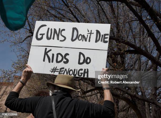 Woman holds a sign over her head referring to school shootings during a 'March For Our Lives' rally in Santa Fe, New Mexico. The rally and march,...