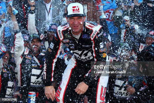 Clint Bowyer, driver of the Haas Automation Demo Day Ford, celebrates in Victory Lane after winning the weather delayed Monster Energy NASCAR Cup...