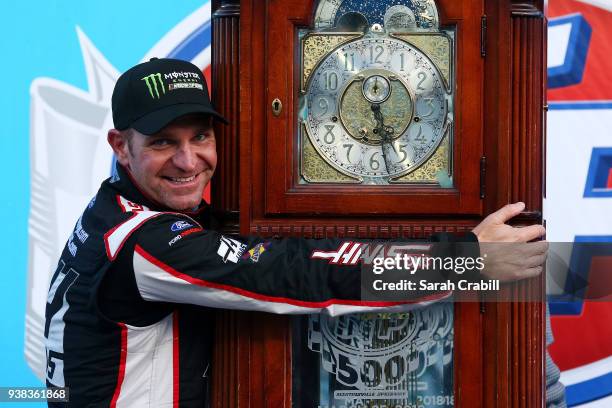 Clint Bowyer, driver of the Haas Automation Demo Day Ford, celebrates with the trophy in Victory Lane after winning the weather delayed Monster...