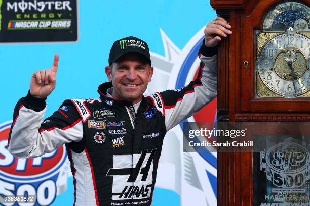 Clint Bowyer, driver of the Haas Automation Demo Day Ford, celebrates with the trophy in Victory Lane after winning the weather delayed Monster...