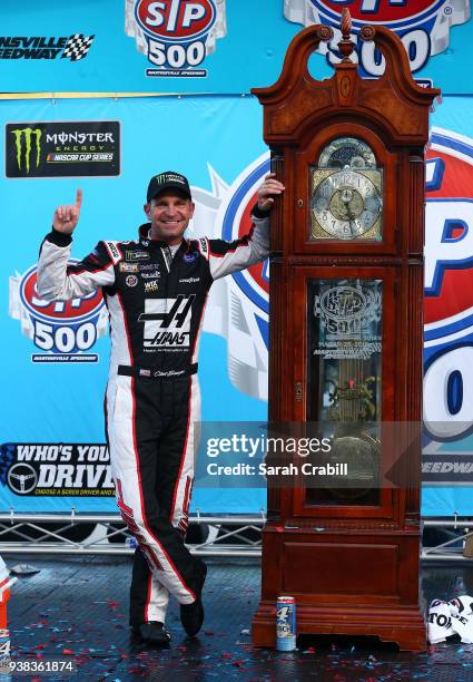 Clint Bowyer, driver of the Haas Automation Demo Day Ford, celebrates with the trophy in Victory Lane after winning the weather delayed Monster...