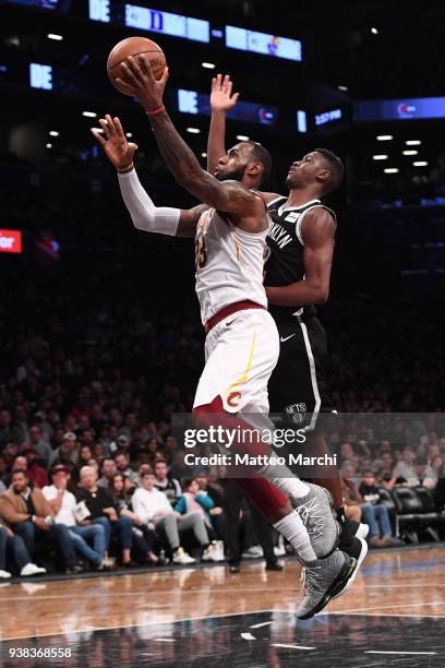 LeBron James of the Cleveland Cavaliers lays up a shot against Caris LeVert of the Brooklyn Nets during the game at Barclays Center on March 25, 2018...