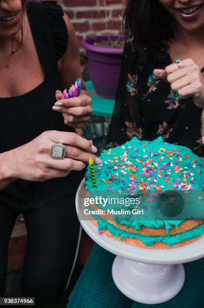 for a muslim girl celebration, placing candles on the cake - muslimgirlcollection ストックフォトと画像