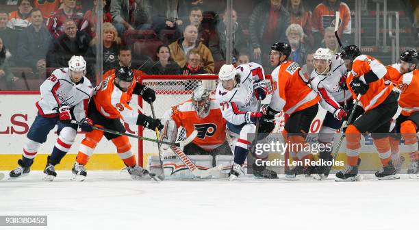 Lars Eller, T.J. Oshie and John Carlson of the Washington Capitals battle for the airborne puck on a scoring opportunity against Radko Gudas, Petr...