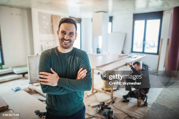 happy home owner with crossed arms at construction site. - confident young man at work stock pictures, royalty-free photos & images