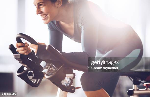 junge glücklich sportlerin mit spinning klasse auf sport-training in einem fitnessstudio. - heimtrainer stock-fotos und bilder