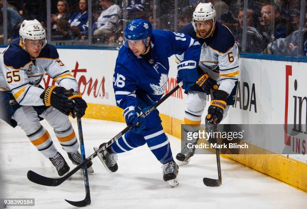 Mitch Marner of the Toronto Maple Leafs skates against Marco Scandella and Rasmus Ristolainen of the Buffalo Sabres during the first period at the...