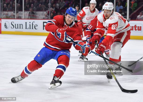 Jonathan Drouin of the Montreal Canadiens passes the puck against pressure from Danny DeKeyser of the Detroit Red Wings in the NHL game at the Bell...