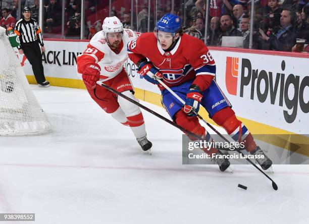 Nikita Scherbak of the Montreal Canadiens skates with the puck under pressure from Xavier Ouellet of the Detroit Red Wings in the NHL game at the...