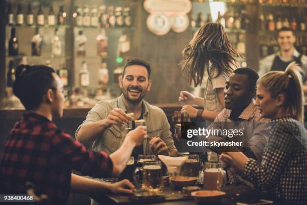 grupp med glada vänner att ha kul medan grillas med vodka shots i en pub. - vodka bildbanksfoton och bilder