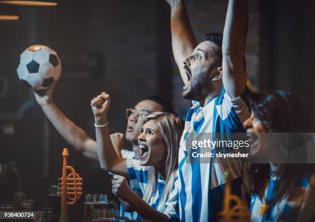 group of excited soccer fans watching successful game on a tv in a bar. - human arm photos stock pictures, royalty-free photos & images
