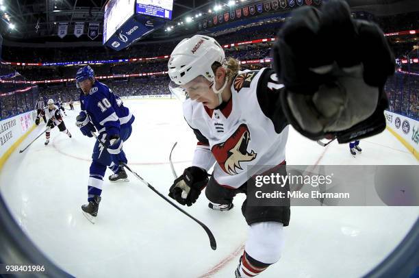 Christian Dvorak of the Arizona Coyotes and J.T. Miller of the Tampa Bay Lightning fight for the puck during a game at Amalie Arena on March 26, 2018...