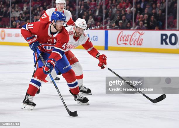 Paul Byron of the Montreal Canadiens skates with the puck under pressure from Luke Glendening of the Detroit Red Wings in the NHL game at the Bell...