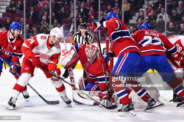 Goaltender Carey Price of the Montreal Canadiens tries to cover a bouncing puck near Gustav Nyquist of the Detroit Red Wings during the NHL game at...