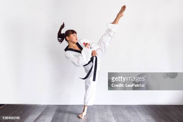 jeune asiatique instructeur de taekwondo obtenir habillé et exercice - arts martiaux photos et images de collection