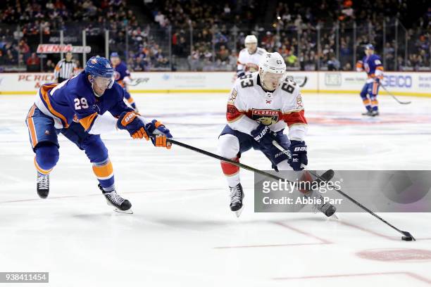Evgenii Dadonov of the Florida Panthers skates with the puck against Brock Nelson of the New York Islanders in the second period during their game at...