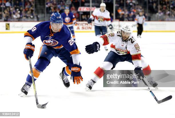 Brock Nelson of the New York Islanders skates with the puck against Vincent Trocheck of the Florida Panthers in the second period during their game...