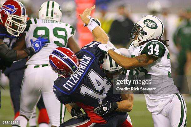 Eric Smith and Marquice Cole of the New York Jets hit quarterback Ryan Fitzpatrick of the Buffalo Bills as he throws the ball at Rogers Centre on...