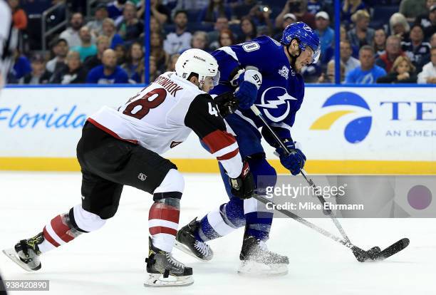 Miller of the Tampa Bay Lightning and Jordan Martinook of the Arizona Coyotes fight for the puck during a game at Amalie Arena on March 26, 2018 in...